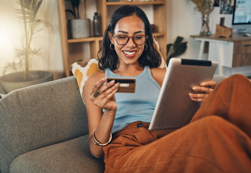 Woman sitting on the couch looking at her credit card